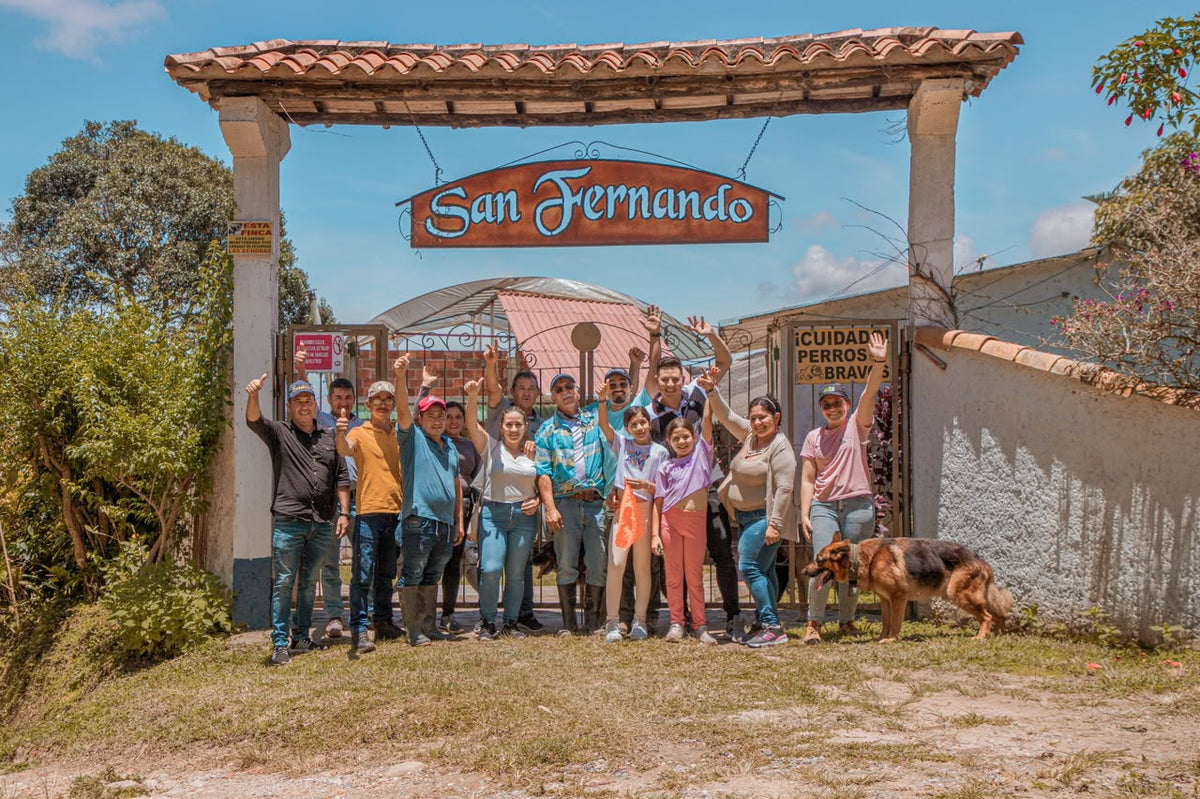 La familia y el equipo de la finca San Fernando frente a la entrada de la finca